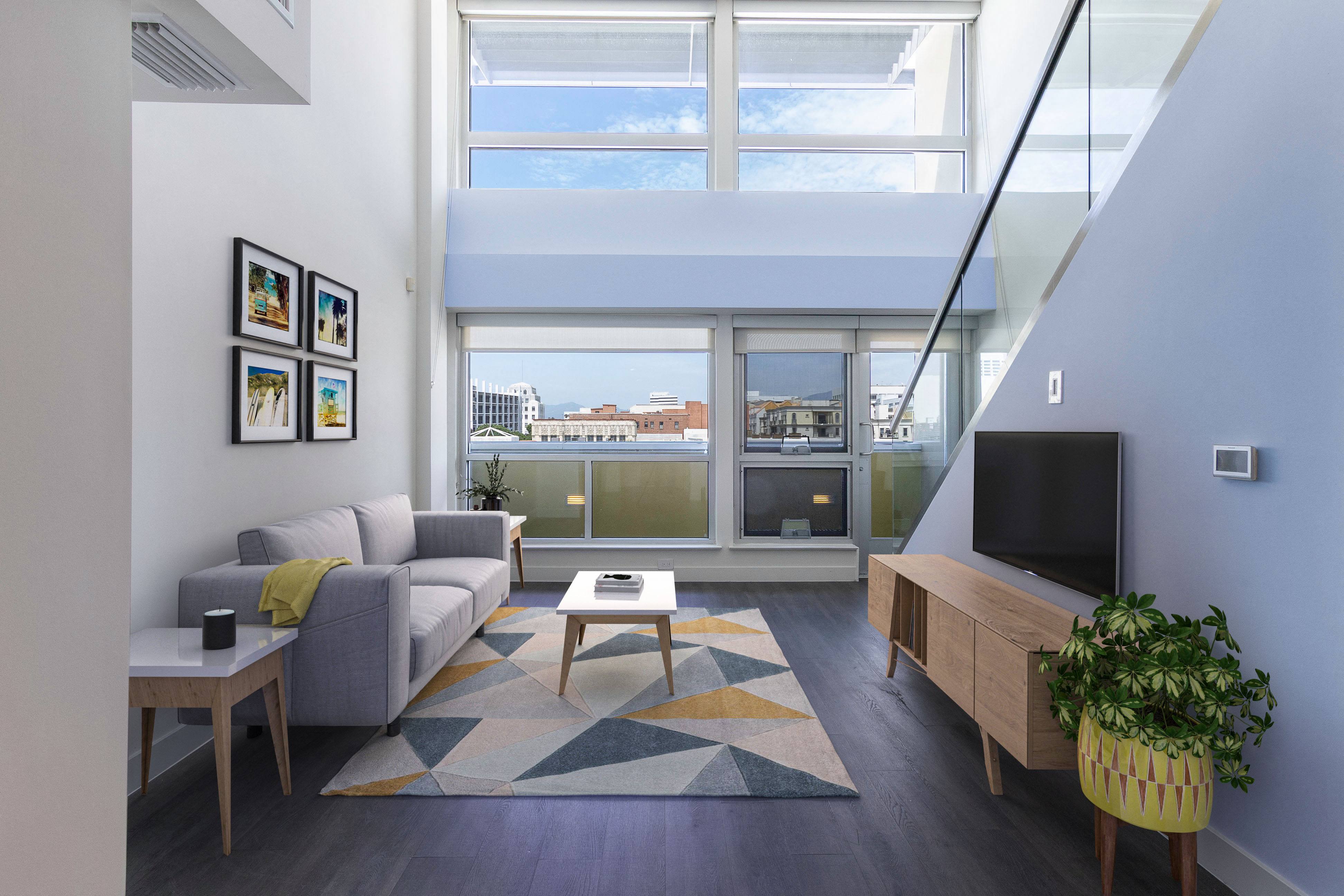 a living room with a couch and a coffee table in front of a large window
